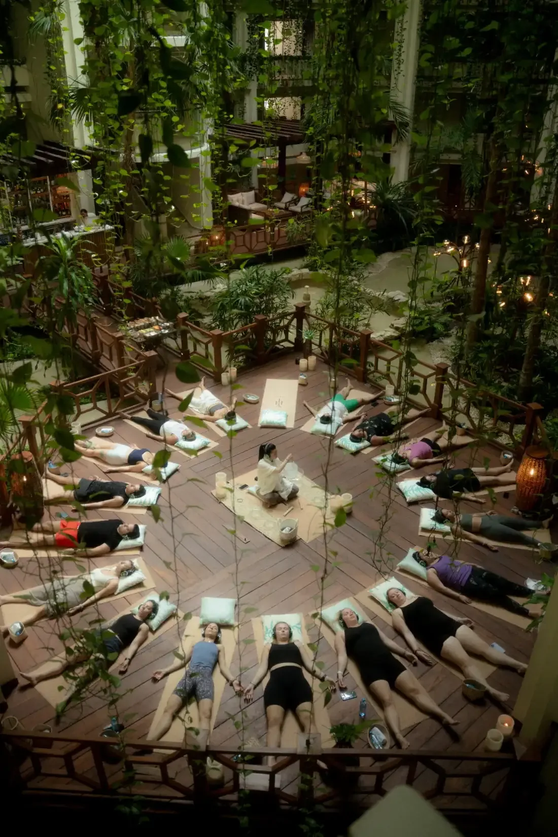 Aerial view of a large group gathered in a circle on a deck within dense jungle